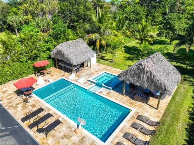 Swimming pool with a patio, an exterior structure, an outbuilding, and a yard
