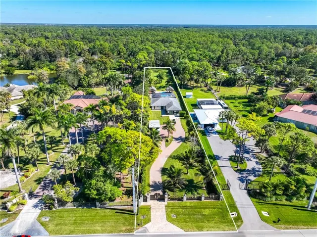 Aerial perspective of suburban area with property parcel outlined and a forest