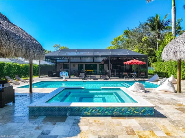 View of swimming pool with a patio area, a lanai, a sunroom, and a pool with connected hot tub