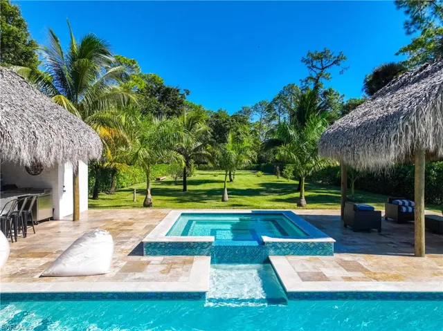 View of pool with a patio area, a lawn, a pool with connected hot tub, and a gazebo