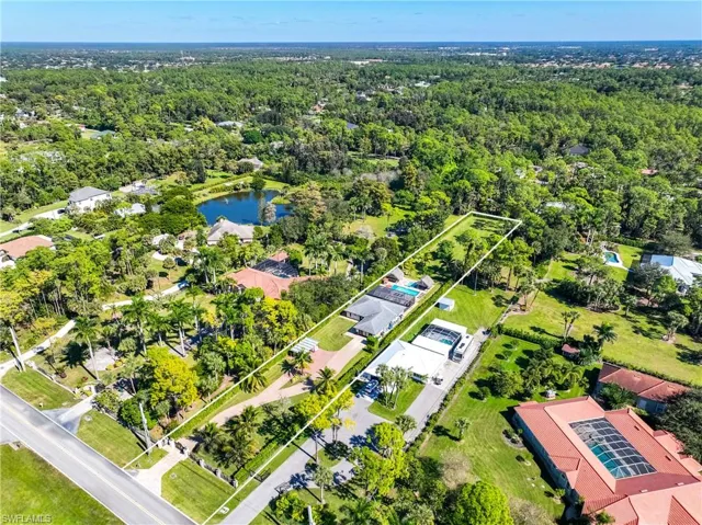 Aerial view of residential area featuring a nearby body of water and property boundaries highlighted