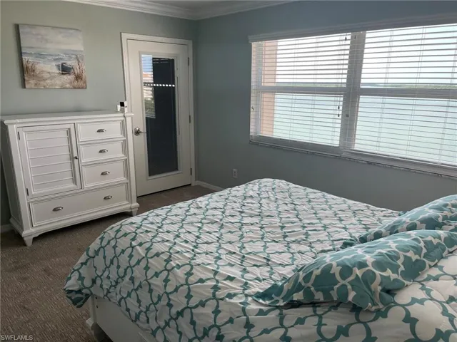 Bright bedroom with expansive windows overlooking water