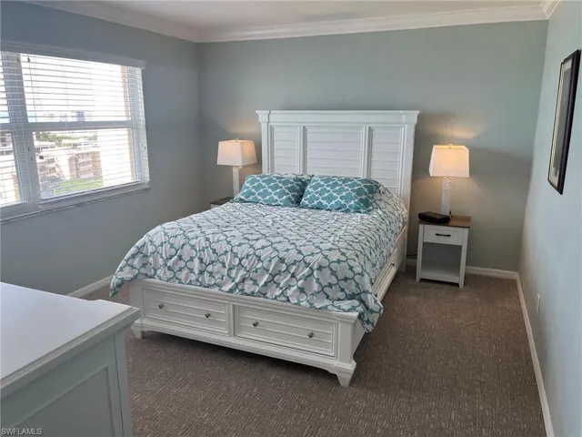 Bedroom featuring light-colored walls and crown molding