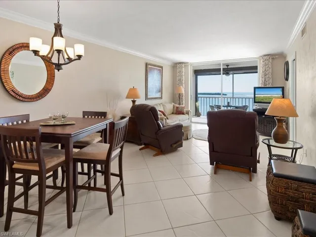 Dining room featuring ornamental molding, a chandelier, and light tile patterned floors