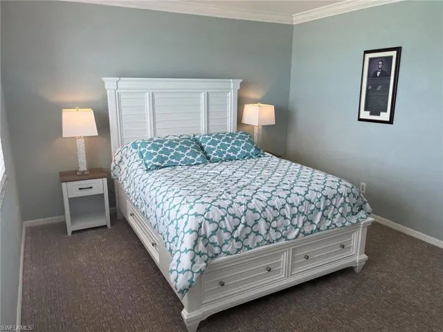 Bedroom featuring light blue wall paint and crown molding