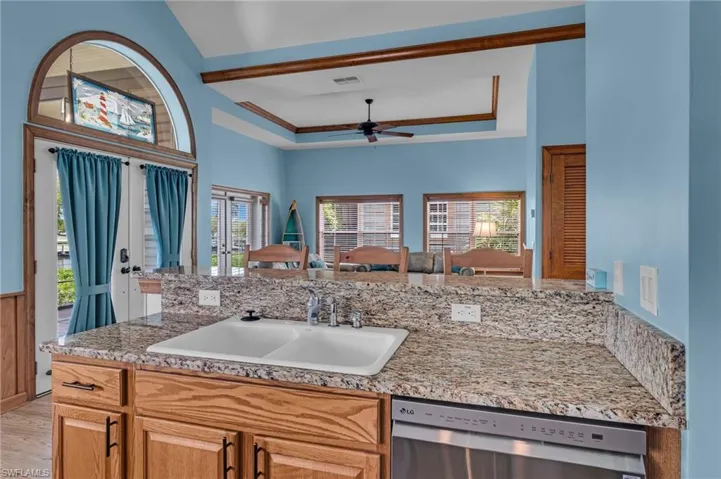 Kitchen featuring dishwasher, visible vents, a sink, light stone countertops, and ceiling fan