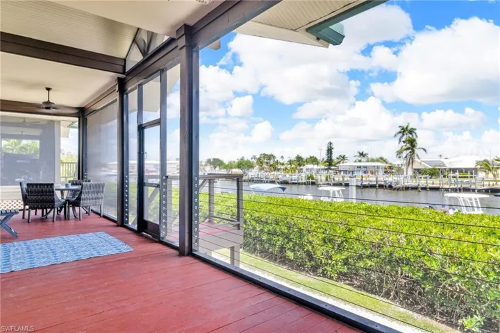Screened patio featuring a water view and ceiling fan