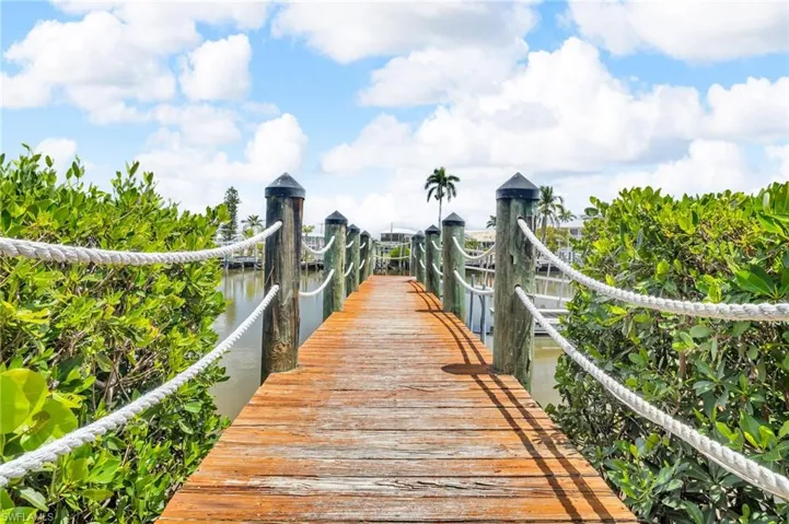 View of property's community featuring a water view and a dock