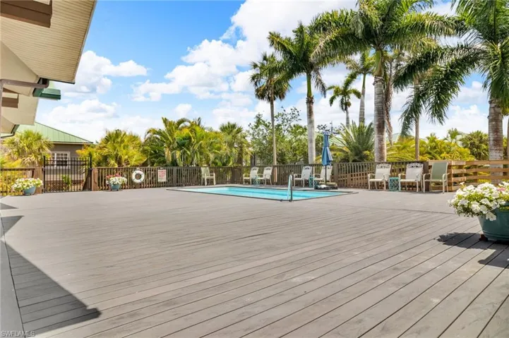 View of pool featuring fence and a deck