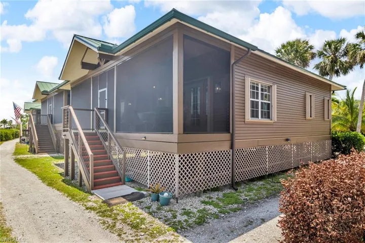 View of side of property with a screened patio and stairway