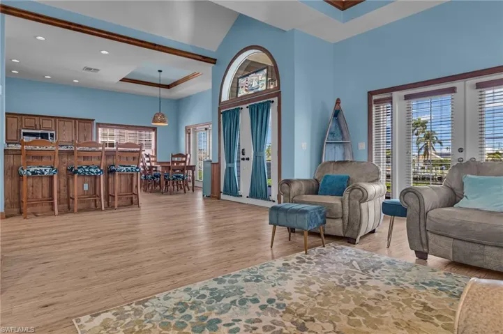 Living area featuring recessed lighting, a high ceiling, visible vents, and light wood-type flooring