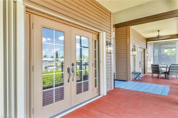 Entryway with wood walls, a ceiling fan, french doors, and laminate finished floors