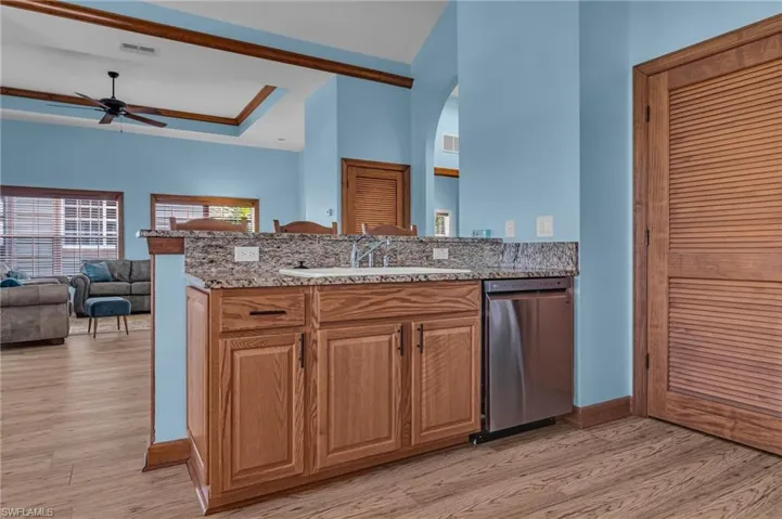 Kitchen featuring light wood finished floors, a sink, visible vents, ceiling fan, and dishwasher