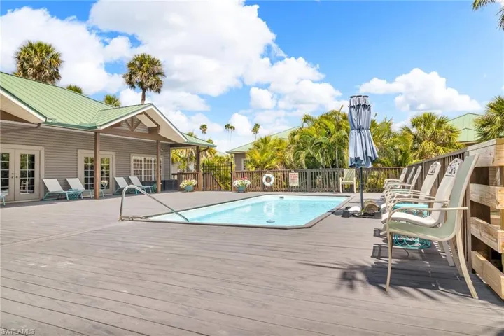 Community pool featuring fence, a wooden deck, and french doors