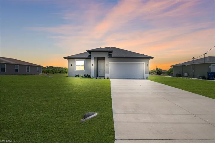 Contemporary stucco exterior featuring a dark gray shingle roof, integrated garage, and a concrete driveway