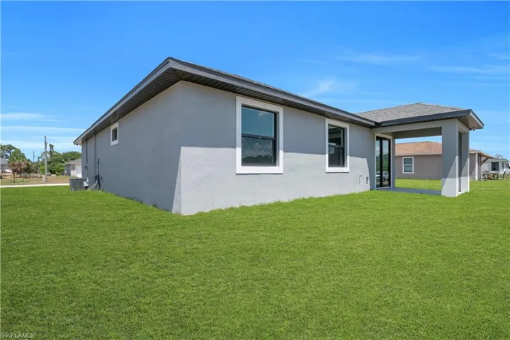 Expansive green lawn surrounds this stucco exterior residence