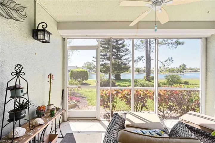 Sunroom featuring tile patterned flooring, a water view, and a textured wall