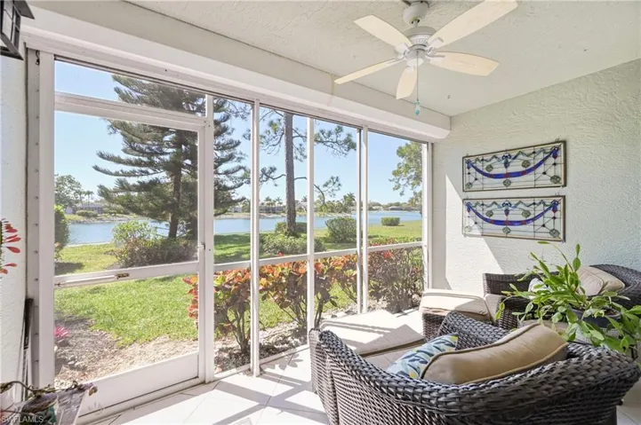 Sunroom / solarium with ceiling fan and a water view