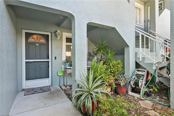Doorway to property featuring stucco siding