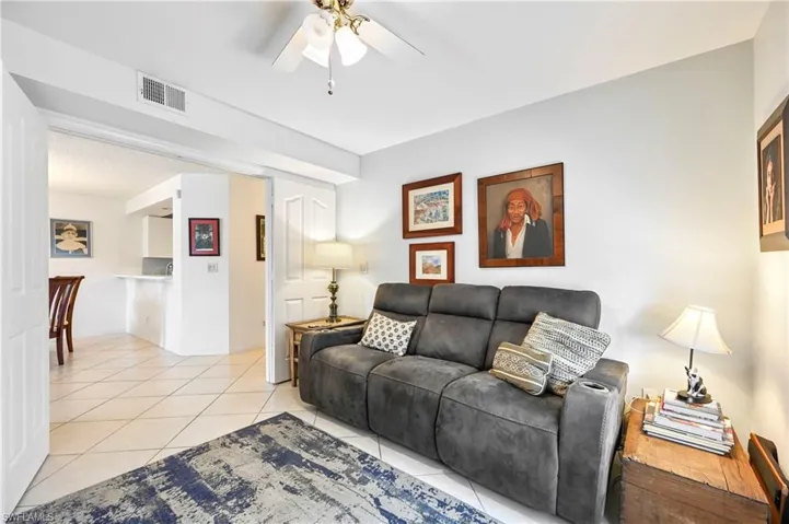 Living area featuring a ceiling fan and light tile patterned floors