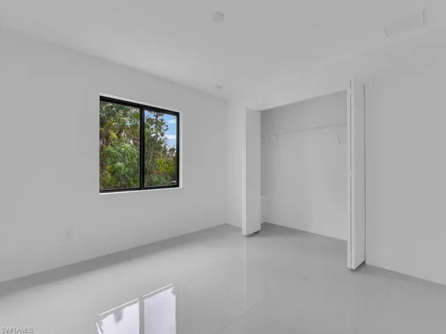 Unfurnished bedroom with a closet and light tile patterned floors
