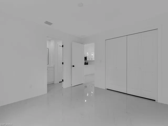 Unfurnished bedroom with light marble finish flooring and a closet