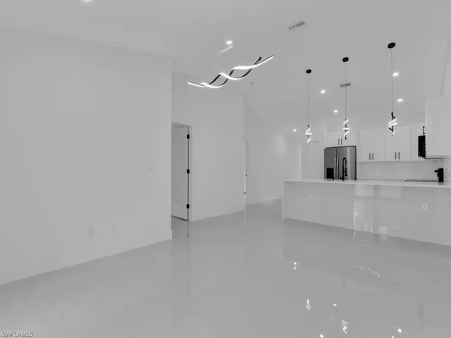 Unfurnished living room featuring recessed lighting and light marble finish flooring