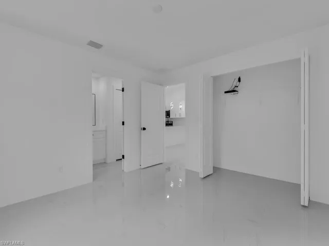 Unfurnished bedroom with a closet and light marble finish floors