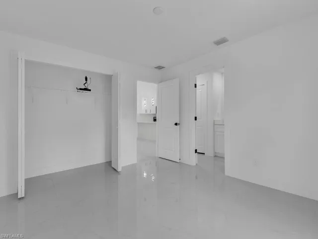 Unfurnished bedroom with a closet and light marble finish flooring