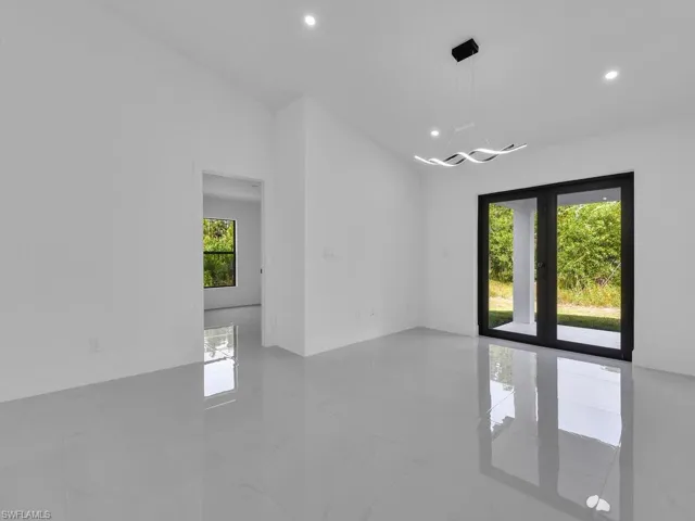 Empty room featuring recessed lighting, light marble finish flooring, and french doors