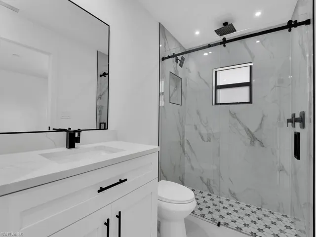 Full bathroom featuring vanity and a marble finish shower