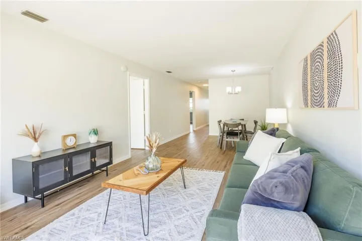 Living room with hardwood / wood-style flooring and an inviting chandelier