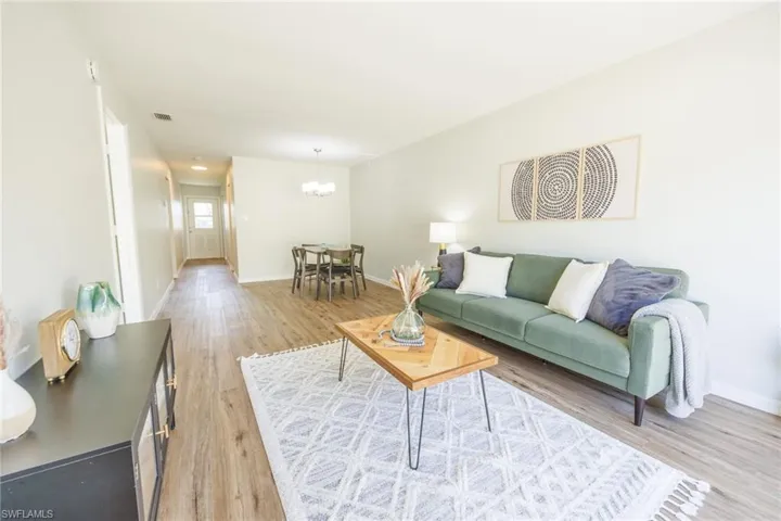 Living room with a chandelier and light hardwood / wood-style flooring