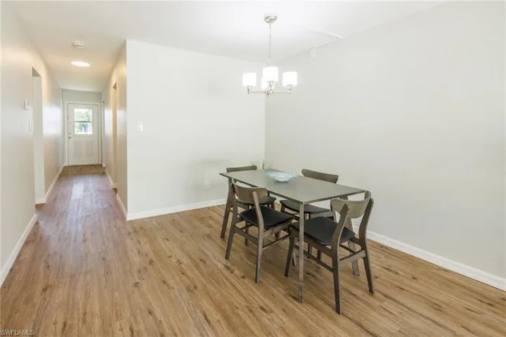 Dining space featuring light wood-type flooring and a notable chandelier