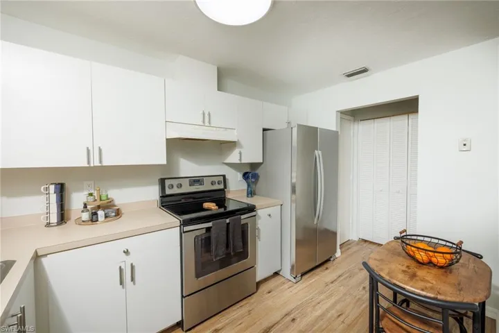 Kitchen featuring white cabinets, light hardwood / wood-style floors, and appliances with stainless steel finishes