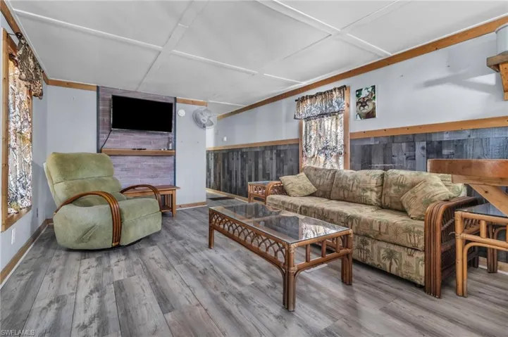 Living area with, baseboards, wood finished floors, and wooden walls