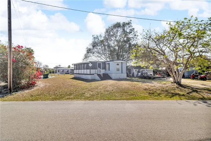 Manufactured / mobile home with a front lawn and a screened in patio