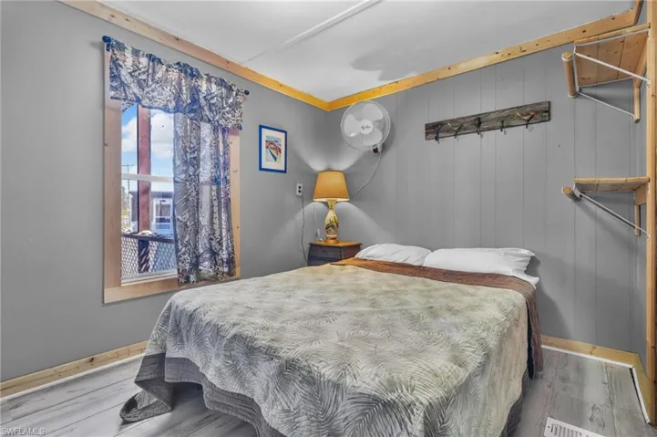 Bedroom featuring wood finished floors and baseboards