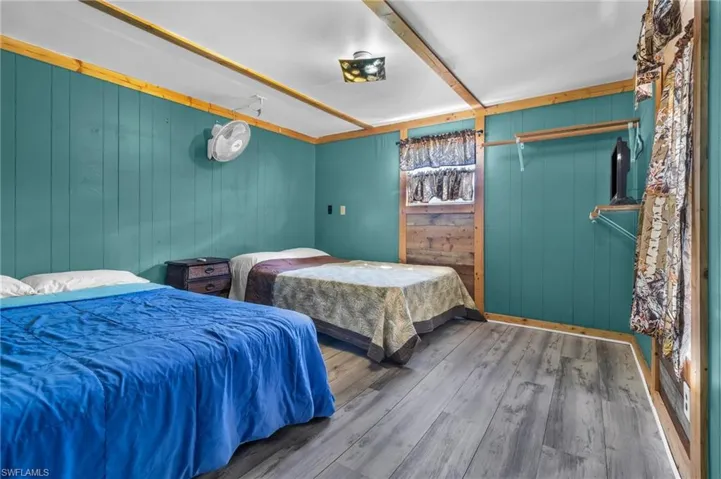 Bedroom with wood walls and wood finished floors