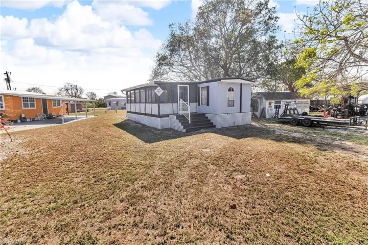 View of front of home with a front lawn and a screened in patio