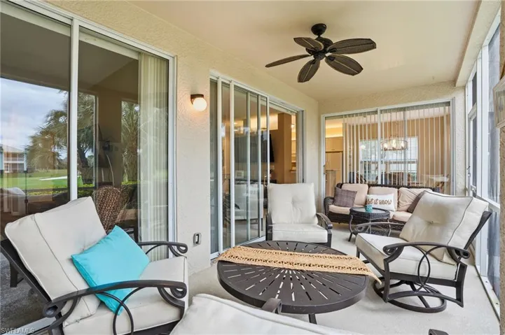 Sunroom with a textured wall, suspended lighting, and carpet floors