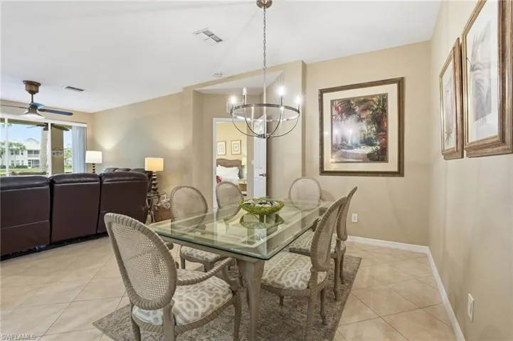 Dining space with ceiling fan, light tile patterned floors, and a chandelier