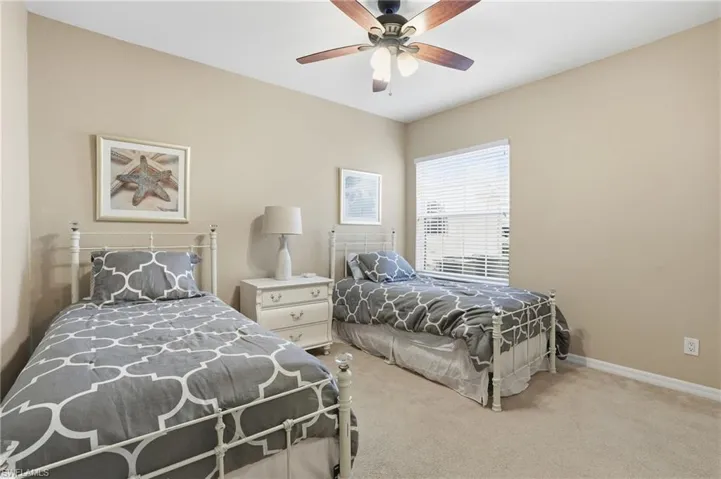 Bedroom with light carpet and a ceiling fan