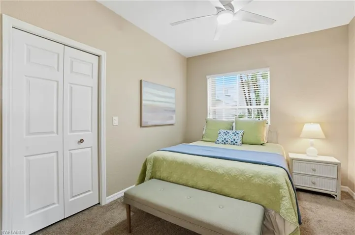 Carpeted bedroom featuring a closet and ceiling fan