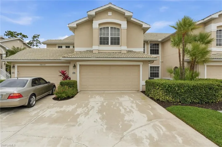 Mediterranean / spanish house with stucco siding, driveway, an attached garage, and a tiled roof