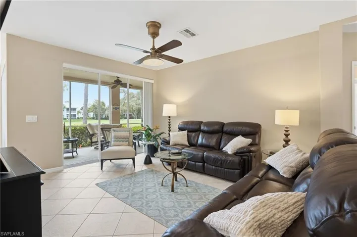 Living area with light tile patterned floors and ceiling fan
