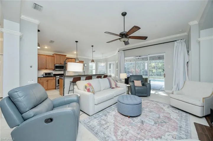 Living area with ornamental molding and ceiling fan