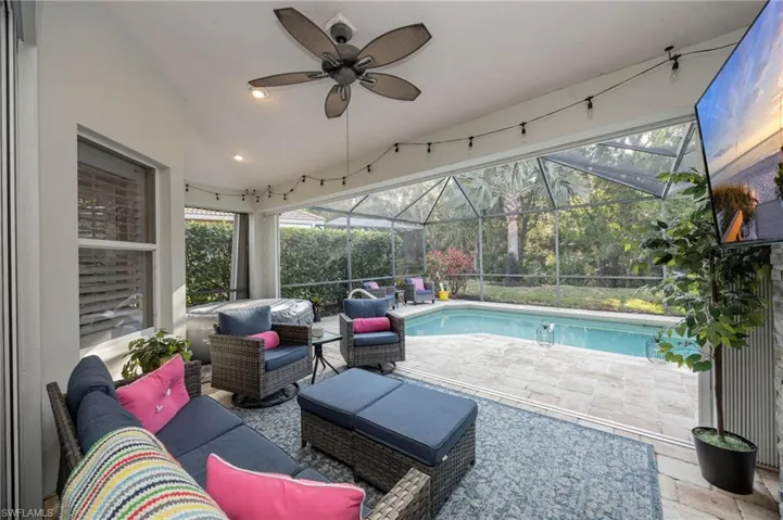 Swimming pool featuring an outdoor lounge area, a patio area, a sunroom, and glass enclosure