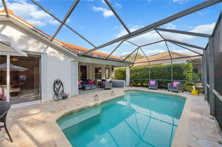 Outdoor pool with a sunroom, a patio, glass enclosure, and outdoor lounge area