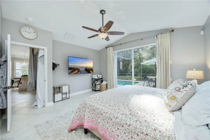 Bedroom with a sunroom, access to exterior, vaulted ceiling, ceiling fan, and light tile patterned flooring